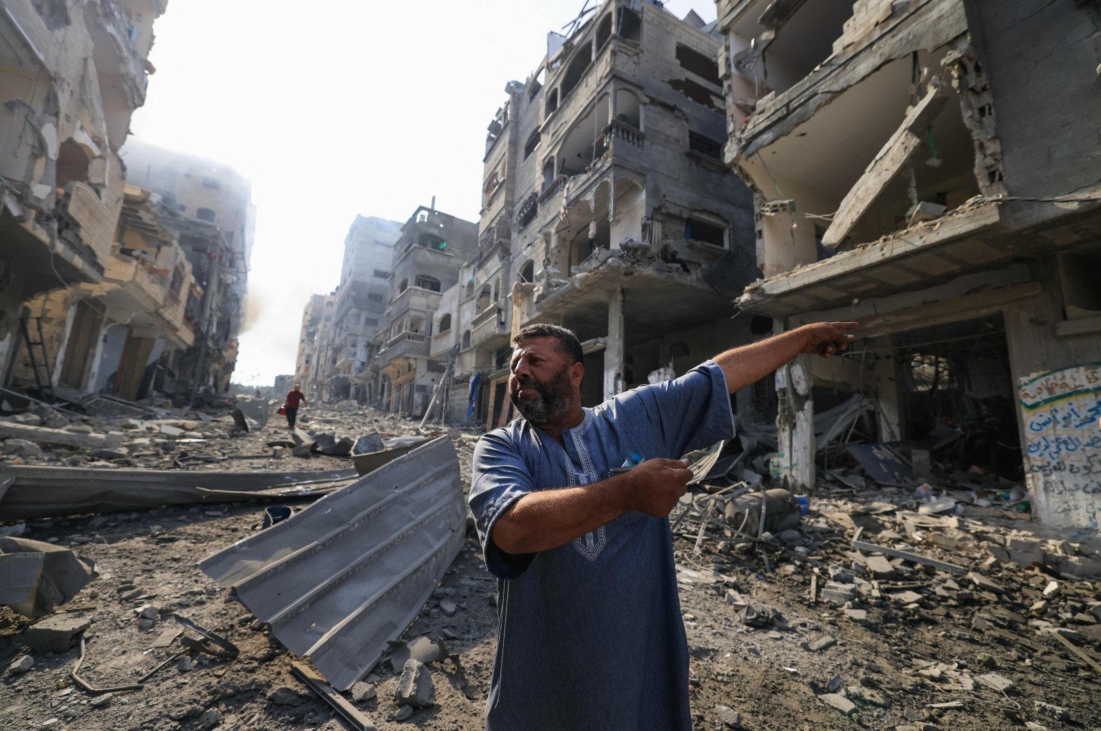 A Palestinian man points at destruction as people inspect the damage following overnight Israeli airstrikes in the Gaza Strip&#039;s Jabalia refugee camp, Oct. 11, 2023. (AFP Photo)