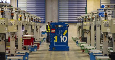 Employees stand between moulding machines in the manufacturing plant at the headquarters of Lego A/S in Billund, Denmark, Feb. 25, 2015. (Getty Images Photo)