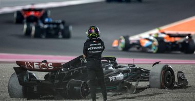 Mercedes' British driver Lewis Hamilton stands next to his damaged car after crashing out of the Qatari Formula One Grand Prix at Lusail International Circuit, Lusail, Qatar, Oct. 8, 2023. (AFP Photo)
