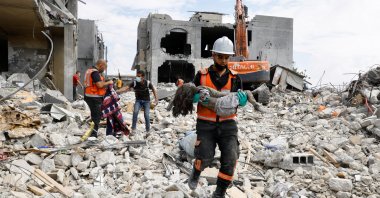 A rescue worker carries the body of a child recovered from under the rubble of a house destroyed by Israeli strikes in Khan Younis in the southern Gaza Strip Oct. 16, 2023. (Reuters Photo)