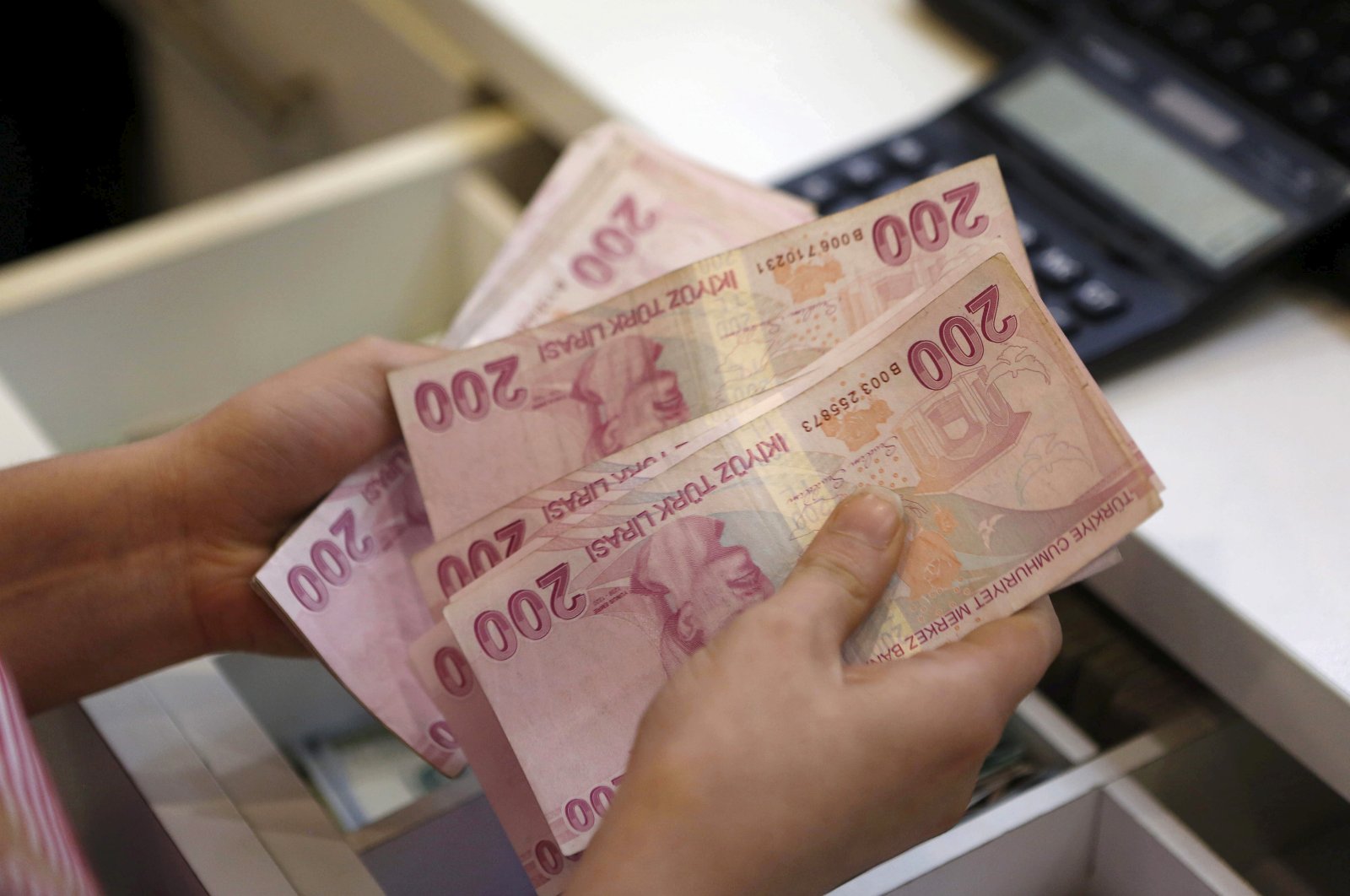 A money changer counts Turkish lira banknotes at a currency exchange office in Istanbul, Türkiye, Aug. 21, 2015. (Reuters Photo)