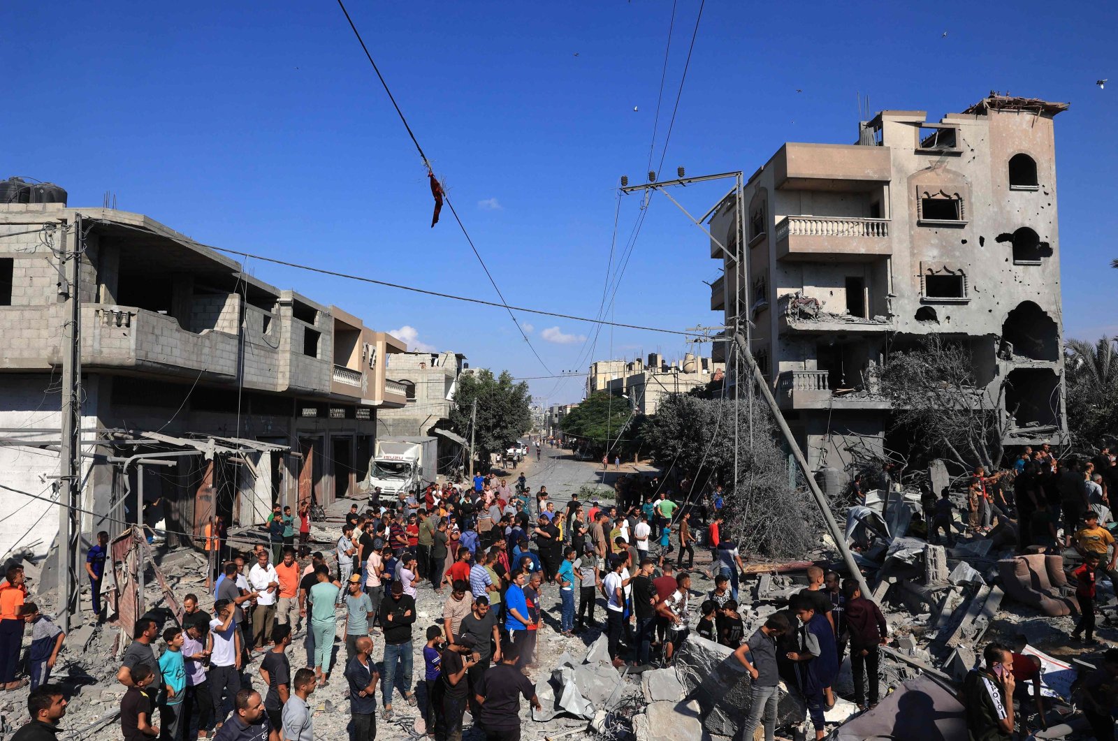 Palestinians gather at the site of collapsed and damaged buildings following an Israeli airstrike in Rafah, in the southern Gaza Strip, Palestine, Oct. 16, 2023. (AFP Photo)