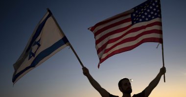 A man waves Israeli and U.S. flags during a protest against plans by Prime Minister Benjamin Netanyahu's new government to overhaul the judicial system, outside of the U.S. Embassy Branch Office in Tel Aviv, Israel, July 13, 2023. (AP Photo)