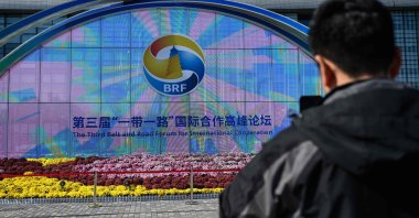 A man takes photos of signage of the Belt and Road Forum in Beijing, China, Oct. 16, 2023. (AFP Photo)