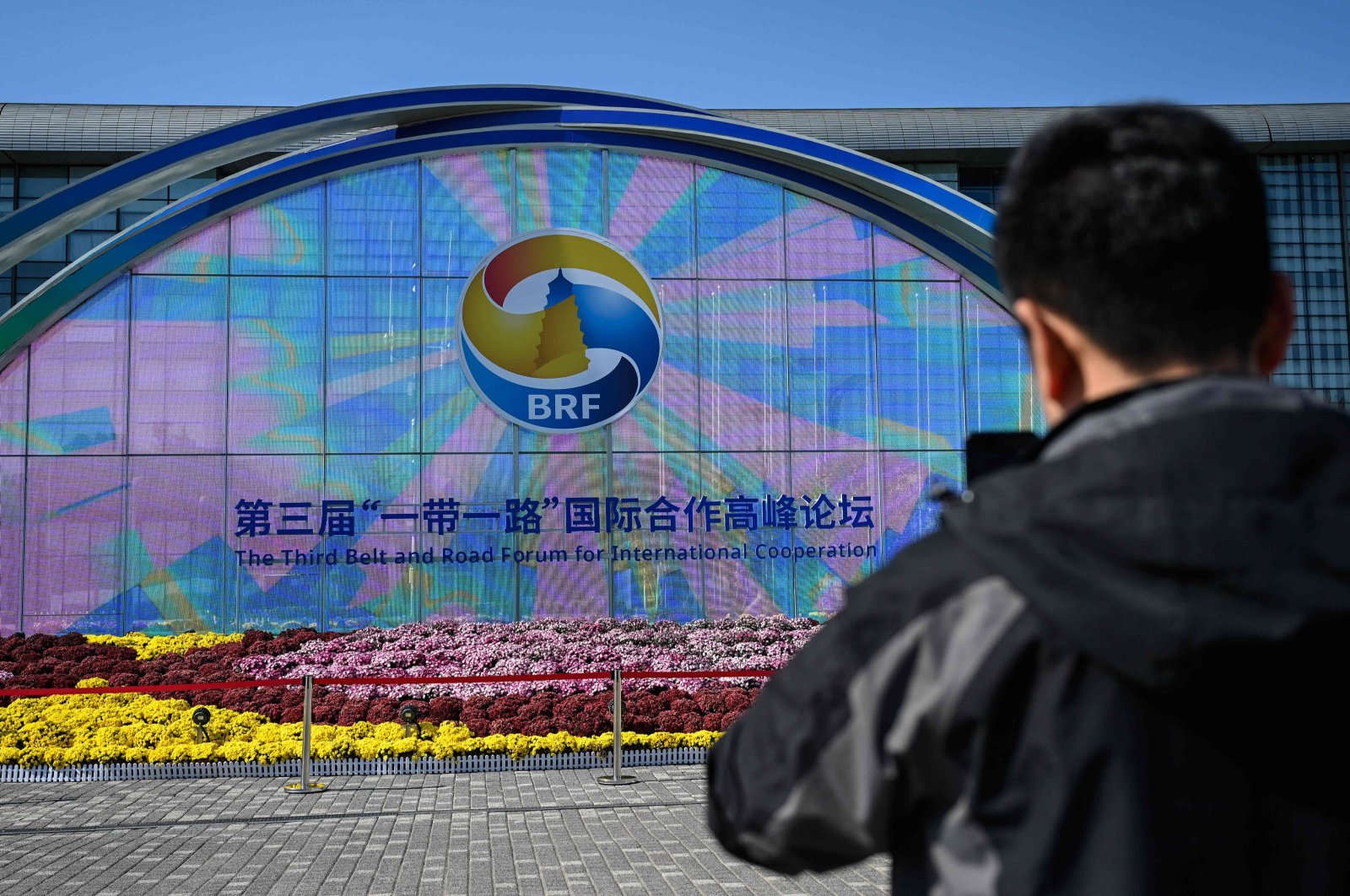 A man takes photos of signage of the Belt and Road Forum in Beijing, China, Oct. 16, 2023. (AFP Photo)