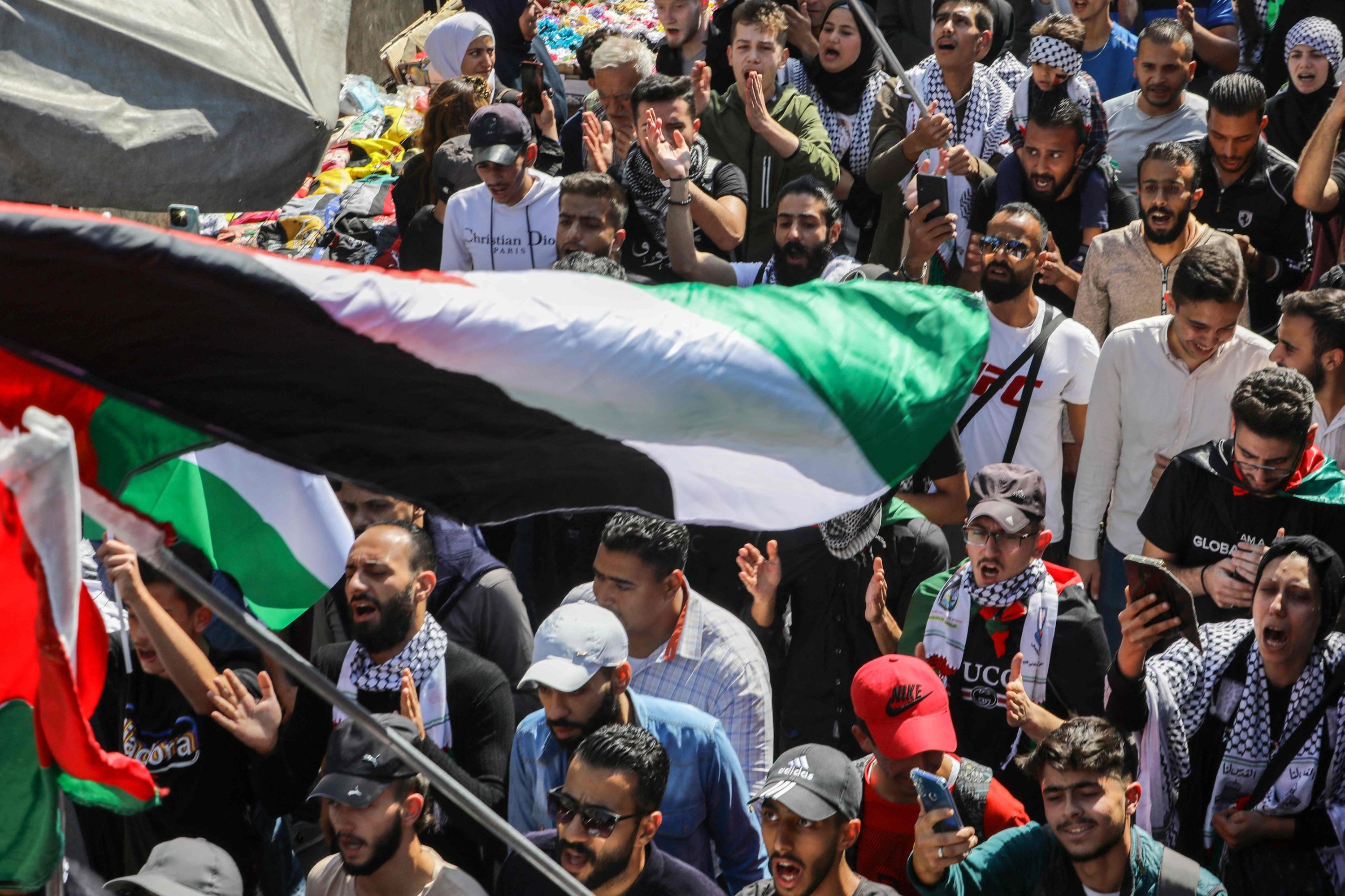 Demonstrators shout slogans and wave Palestinian and Syrian flags as they protest in Damascus, Syria, Oct. 18, 2023.