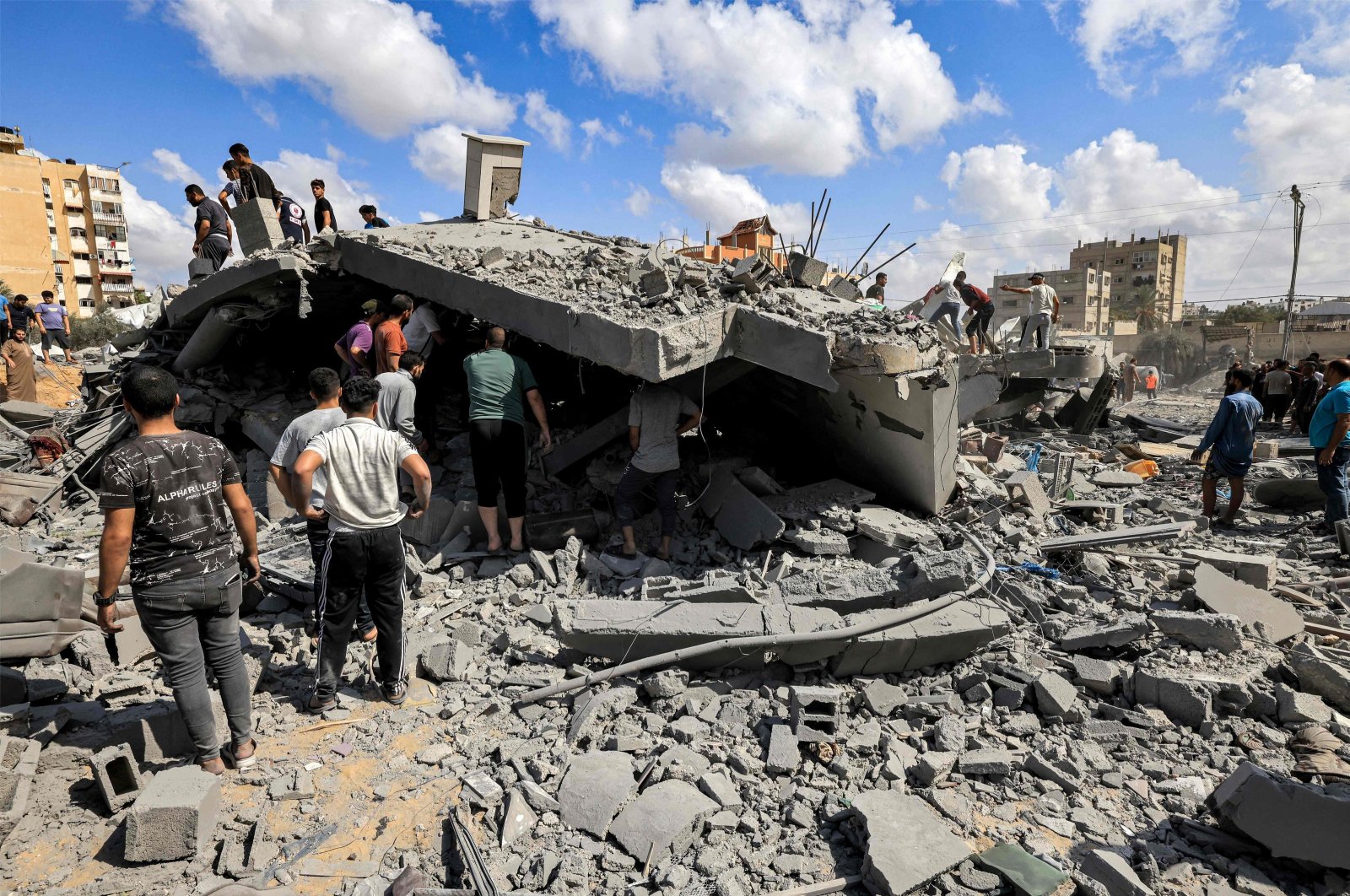 People inspect the remains of a destroyed building following Israeli bombardment in Khan Yunis, Gaza Strip, Palestine, Oct. 18, 2023. (AFP Photo)