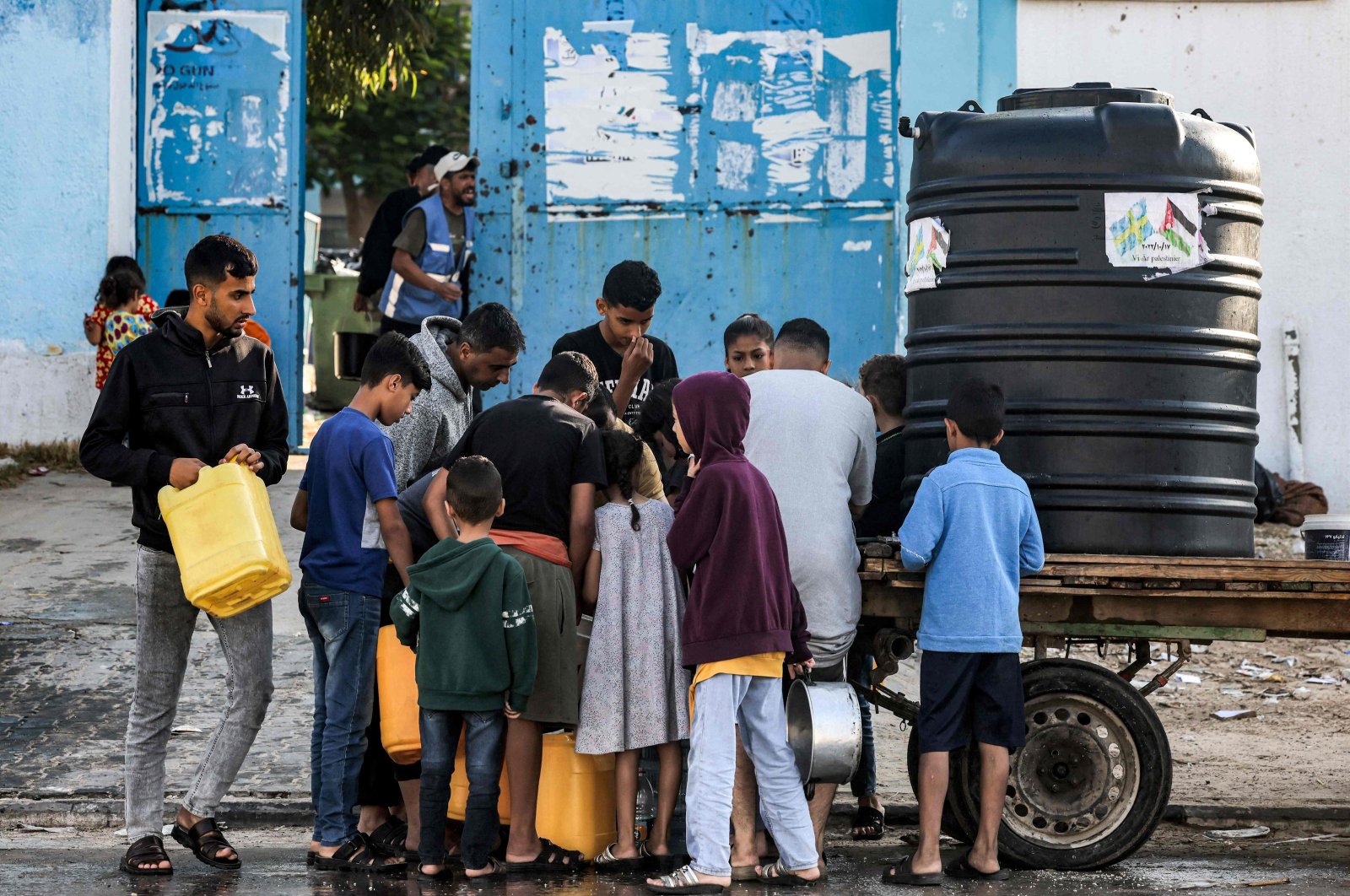 Men and children arrive with jerry cans to fill up water from a portable cistern mounted on a cart in Rafah in the southern Gaza Strip, Palestine, on Oct. 19, 2023. (AFP Photo)