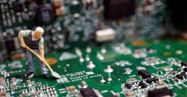 A worker miniature is placed among printed circuit boards with semiconductor chips, in this illustration taken on July 5, 2023. (Reuters Photo)