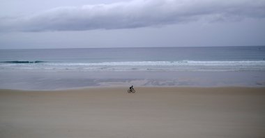A cyclist rides on his bicycle on the beach of Razo facing the Atlantic Ocean, near A Coruna, Galicia, Spain, Oct. 16, 2023. (Reuters Photo)