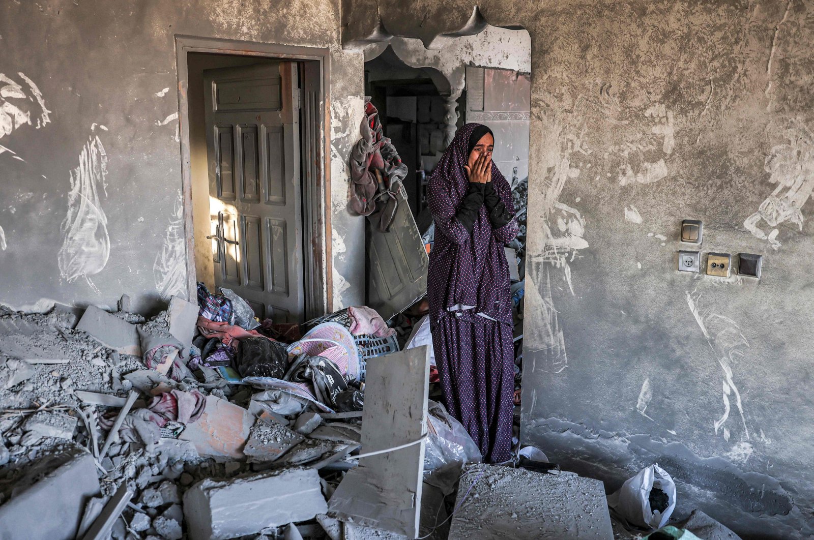 A woman reacts as she stands in a heavily damaged house following Israeli bombardment in Rafah in the southern of Gaza Strip, Palestine, Oct. 19, 2023. (AFP Photo)