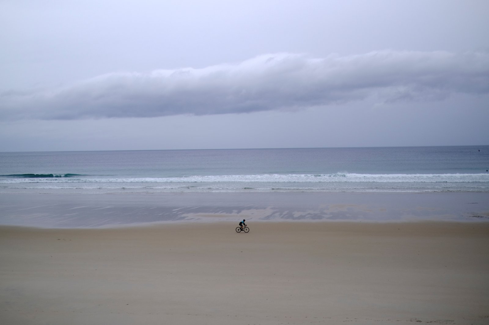 A cyclist rides on his bicycle on the beach of Razo facing the Atlantic Ocean, near A Coruna, Galicia, Spain, Oct. 16, 2023. (Reuters Photo)