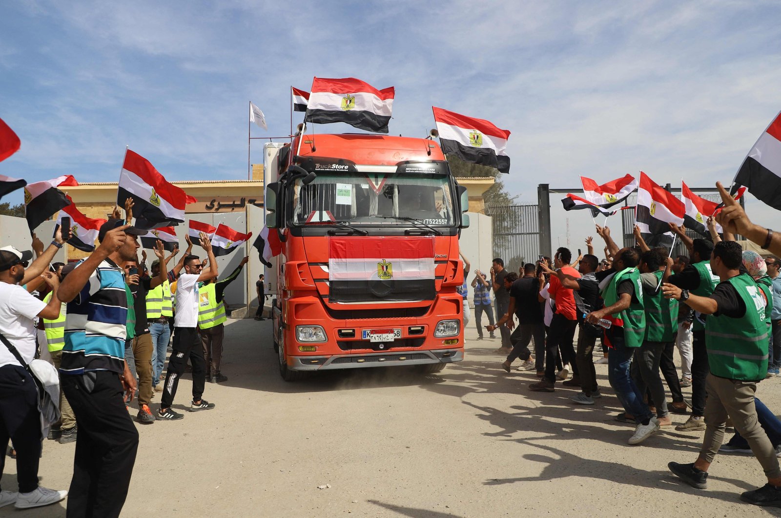  Egyptian aid workers celebrate as an aid truck crosses back into Egypt through the Rafah border crossing with the Gaza Strip on Oct. 21, 2023. (AFP Photo)