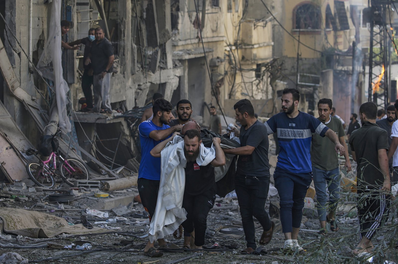 Palestinians carry a wounded man following an Israeli airstrike in Gaza, Oct. 21, 2023. (EPA Photo)