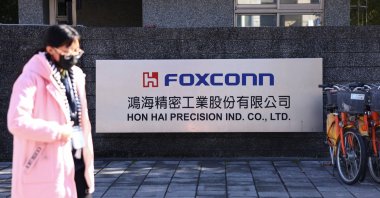 A woman walks past the logo of Foxconn outside a company&#039;s building, in New Taipei City, Taiwan Dec. 22, 2022. (Reuters Photo)