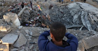A young boy looks on as people check the rubble of a building destroyed in an Israeli bombardment in Rafah in the southern Gaza Strip, Palestine, Oct. 21, 2023. (AFP Photo)