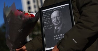 A fan is seen with a framed Bobby Charlton picture and flowers outside Old Trafford, Manchester, U.K., Oct. 22, 2023. (Reuters Photo)