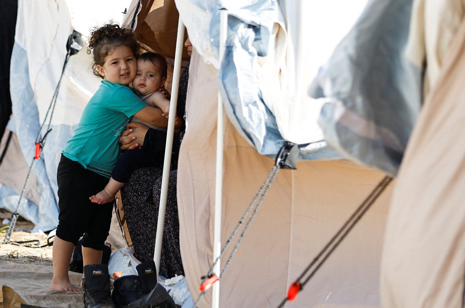 Children hug as Palestinians take shelter in a tent camp at a U.N.-run center in Khan Younis, southern Gaza Strip, Oct. 19, 2023. (Reuters Photo)