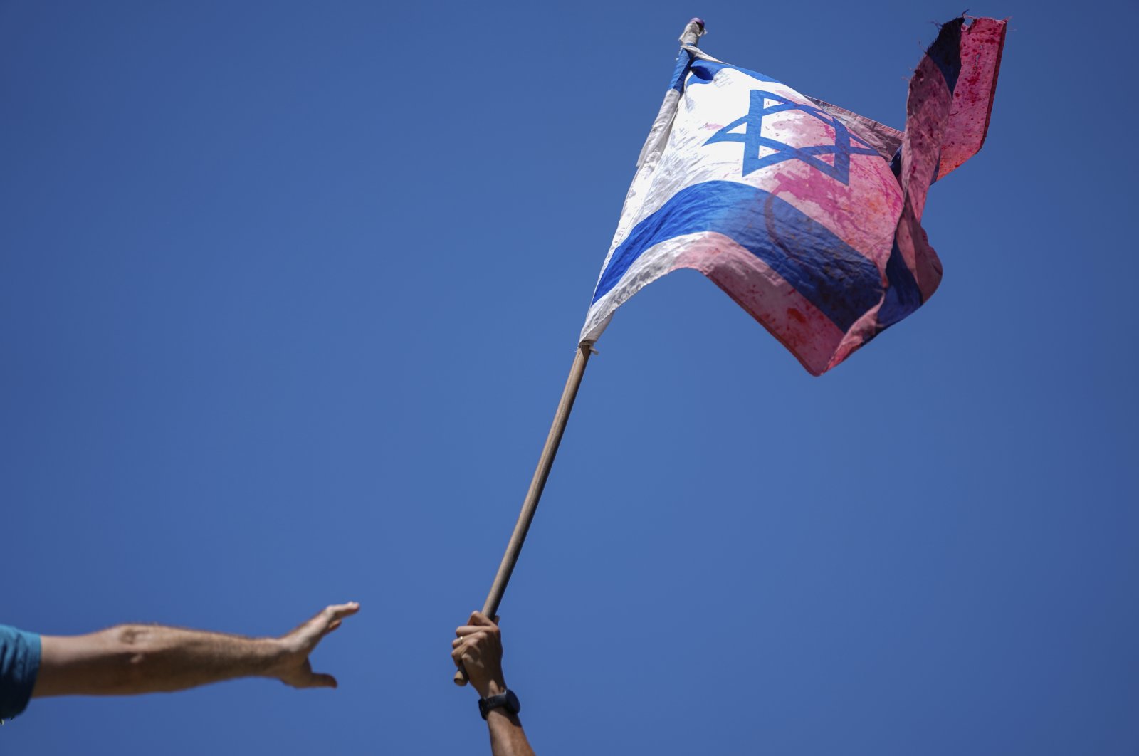 A demonstrator waves a colored Israeli flag during a protest against plans by Prime Minister Benjamin Netanyahu&#039;s government to overhaul the judicial system, outside the Knesset, Israel&#039;s parliament, in Jerusalem, July 24, 2023. (AP Photo)