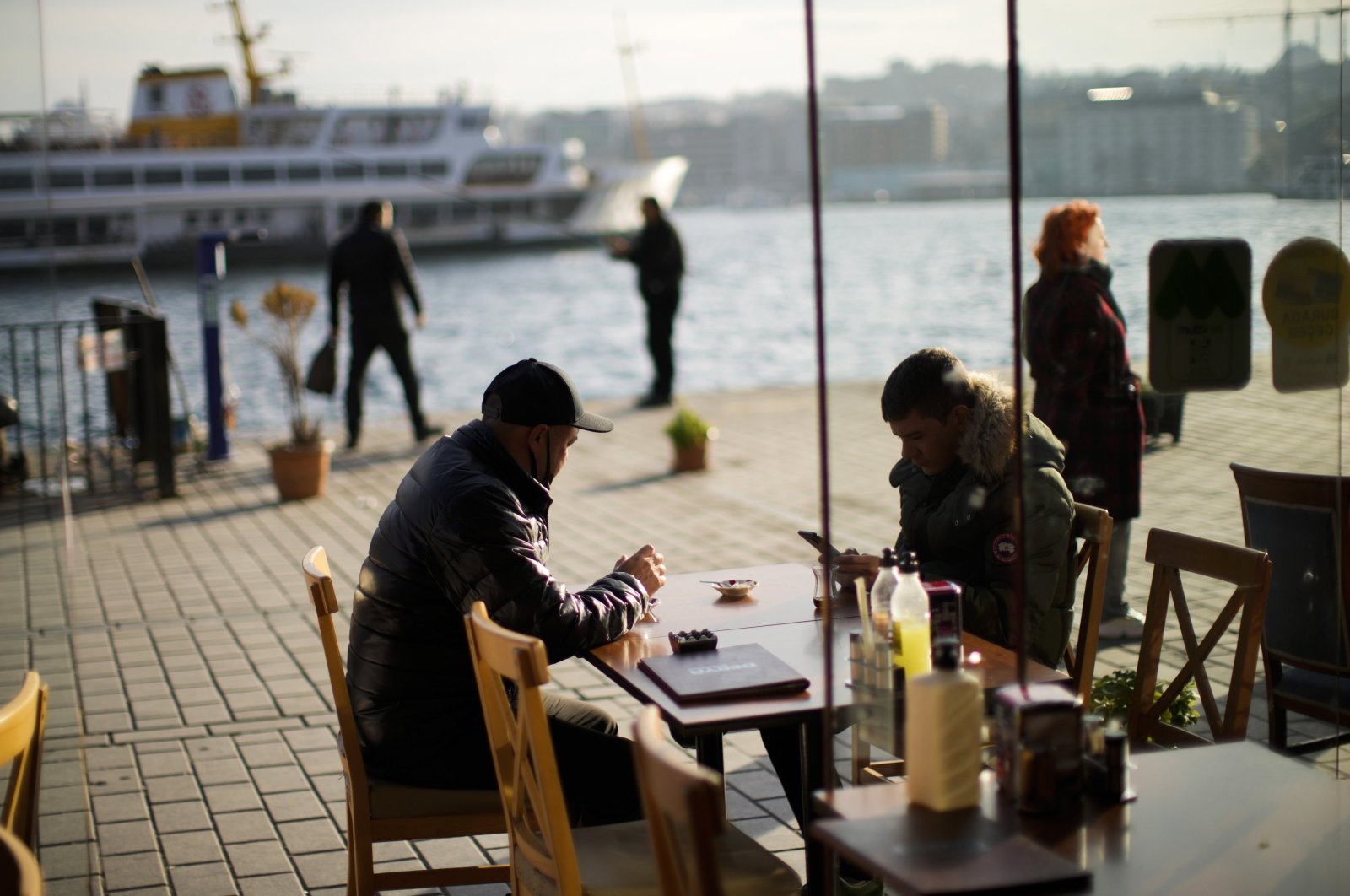 Istanbulites are photographed drinking tea in a local restaurant at the Karaköy ferry terminal in Istanbul, Türkiye, Jan. 3, 2022. (AP Photo)
