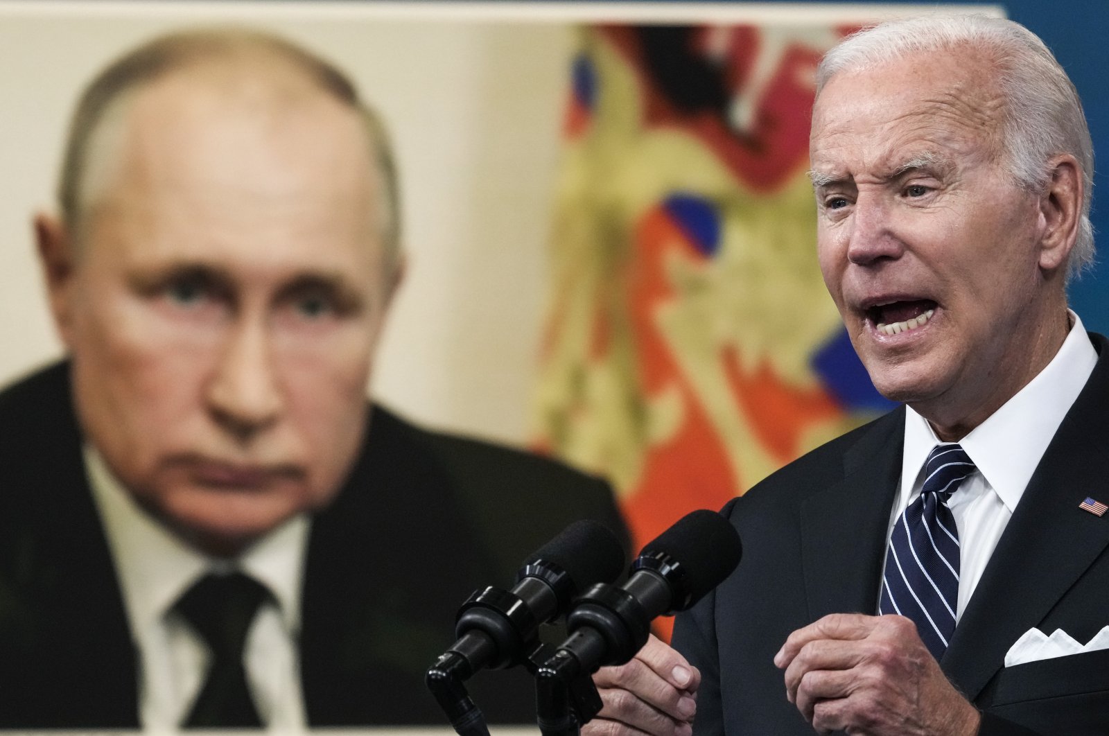 An image of Russian President Vladimir Putin (L) is displayed as U.S. President Joe Biden speaks about gas prices in the South Court Auditorium at the White House in Washington, D.C., U.S., June 22, 2022. (Getty Images Photo)