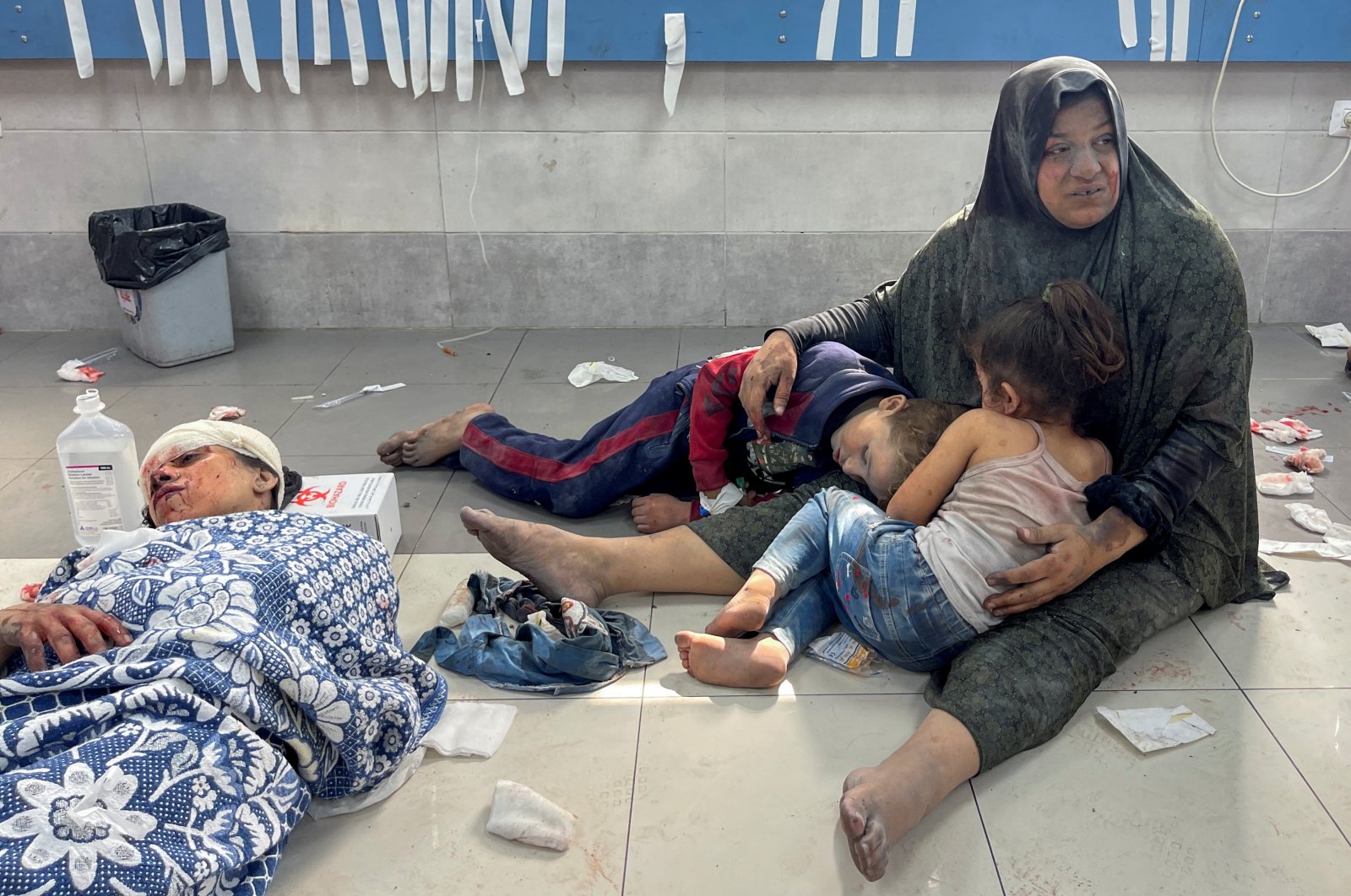  A Palestinian woman holds her children, who were wounded along with her in an Israeli strike, at Shifa hospital in Gaza City, Oct. 23, 2023. (Reuters Photo)