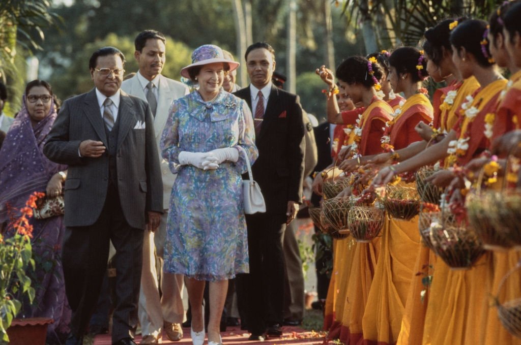 Bengali politician AFM Ahsanuddin Chowdhury, president of Bangladesh, with British royal, Queen Elizabeth II, wearing a floral print dress and matching hat, during a visit to the village of Bairagpur, Bangladesh, Nov. 17, 1983. (Getty Images Photo)