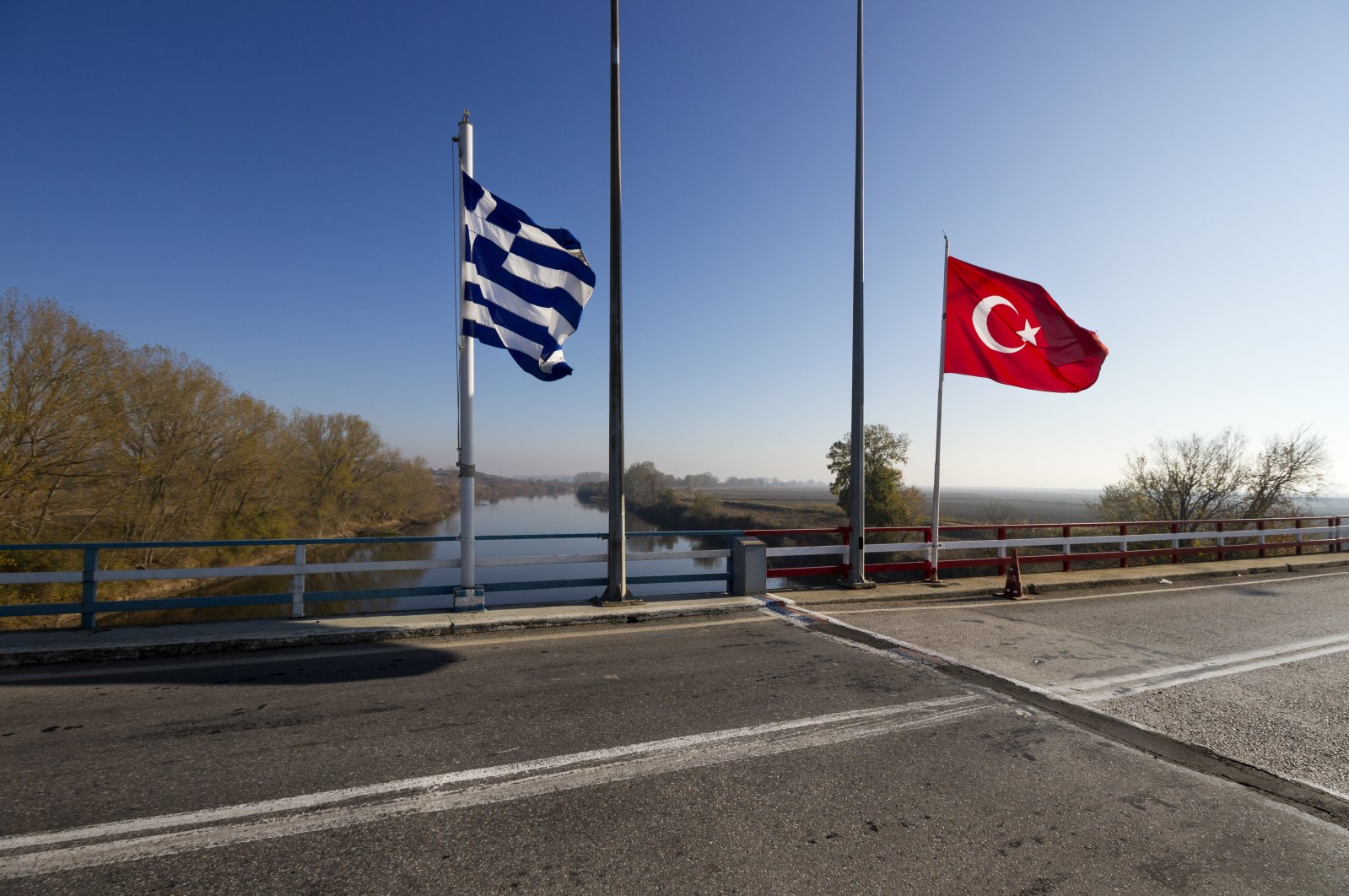 The Greek-Turkish border line right on the bridge over the Martisa (Meriç) River between the two countries. Greece and Türkiye are on the path to improvement of their relations at the centenary of the Republic of Türkiye. (Shutterstock Photo)