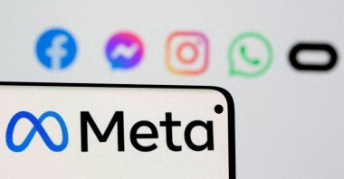 Facebook's new rebrand logo Meta is seen on smartphone in front of a displayed logo of Facebook, Messenger, Instagram, WhatsApp and Oculus in this illustration picture taken Oct. 28, 2021. (Reuters Photo)