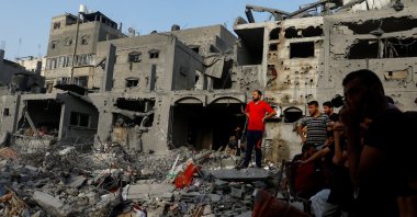 Palestinians look on during a search for casualties at the site of Israeli strikes on houses, in Khan Younis, in the southern Gaza Strip, October 25, 2023. REUTERS/Ibraheem Abu Mustafa