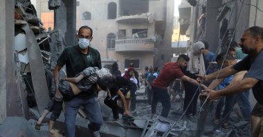 A Palestinian man carries a child killed in an Israeli strike on a house in Khan Younis in the southern Gaza Strip, Palestine, Oct. 19, 2023. (Reuters Photo)