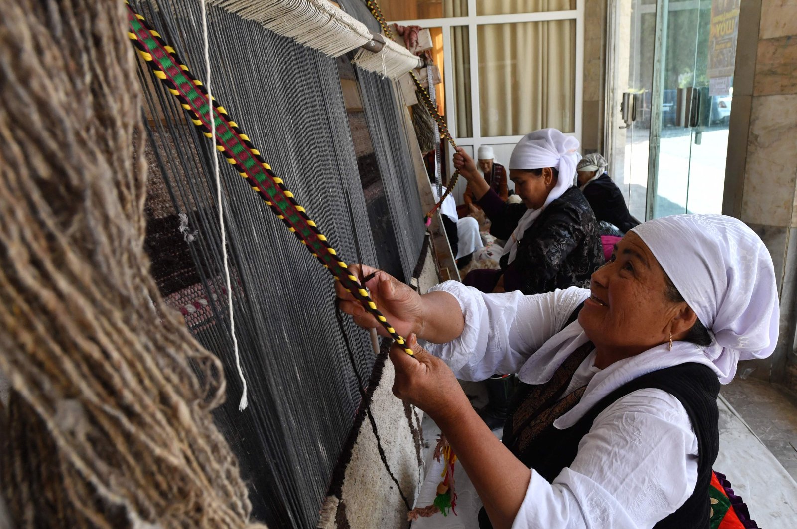 A group of older women calling themselves the &quot;Happy Grandmas&quot; work on weaving Shyrdaks – traditional Kyrgyz woolen rugs, at the House of Culture of the Metallurgists of Kadamjay – a city built in the 1930s around a huge metals factory that is now shut down, Batken, Kyrgyzstan, Oct. 2, 2023. (AFP Photo)