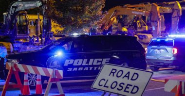 A police car drives past a roadblock sign on the road leading to Schemengees bar where a man reportedly opened fire killing and injuring numerous people in Lewiston, Maine, U.S., Oct. 25 2023. (EPA Photo)