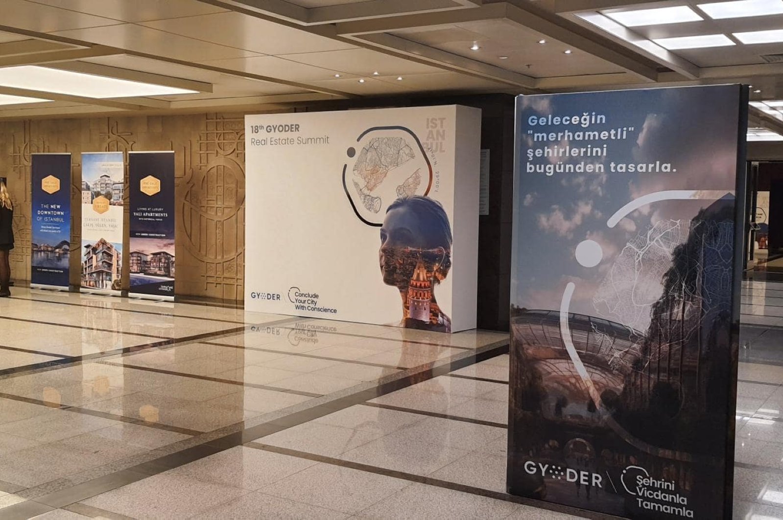 Organizers walk past posters reading “Conclude Your City With Conscience" ahead of the 18th GYODER Summit, Istanbul, Türkiye, Oct. 25, 2023. (Photo by Amina Ali)