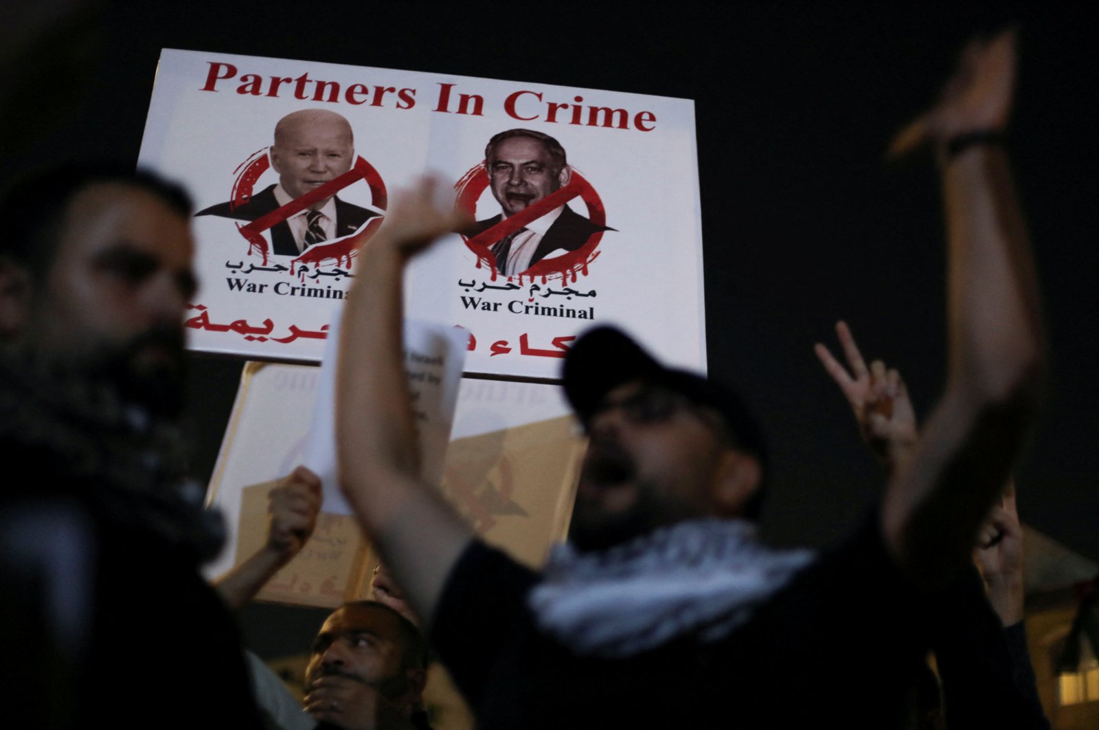 A banner depicting U.S. President Joe Biden and Israeli Prime Minister Benjamin Netanyahu is seen as Jordanians gather during a protest in support of Palestinians in Gaza, near the Israeli embassy, in Amman, Jordan, Oct. 24, 2023. (Reuters Photo)