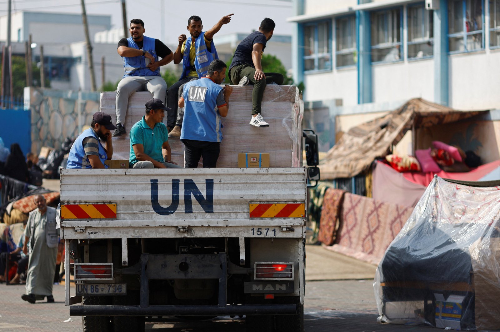 United Nations workers arrive to distribute aid to Palestinians, who have fled their homes due to Israeli strikes, and take shelter in a U.N.-run school, in Khan Younis in the southern Gaza Strip, Oct. 23, 2023. (Reuters Photo)