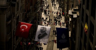 An image of Mustafa Kemal Ataturk, hangs next to a national flag over Istiklal Street, in Istanbul, Türkiye, Oct. 25, 2023. (AP Photo)