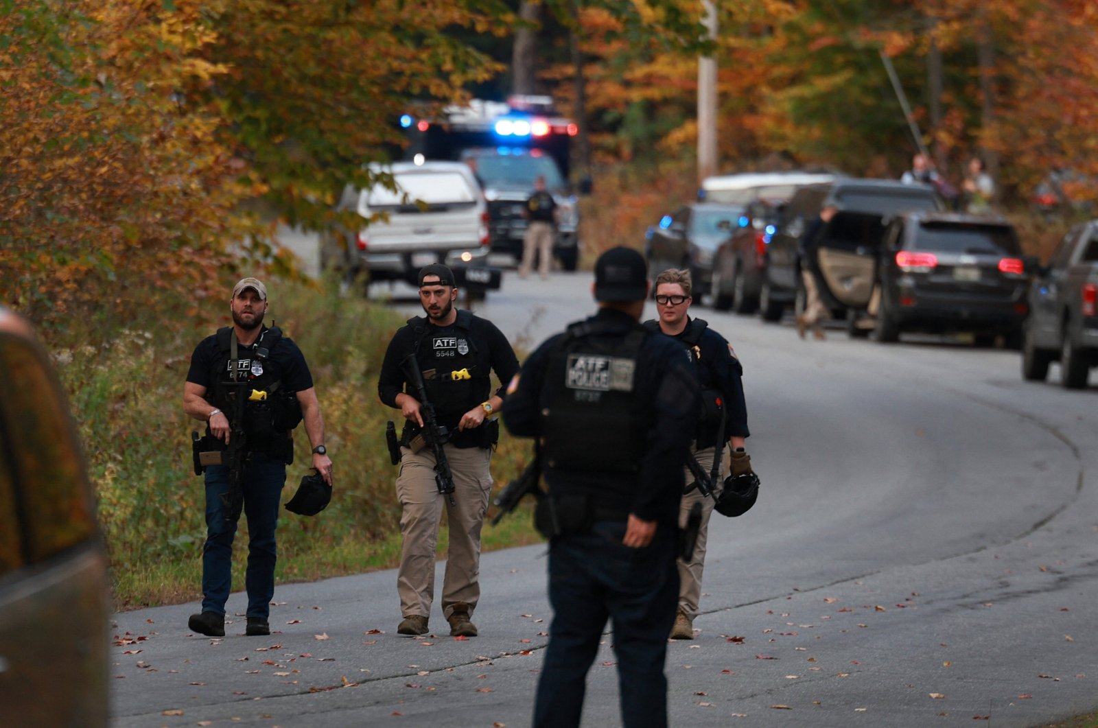 Law enforcement officials gather in the road leading to the home of the suspect being sought in connection with two mass shootings, Bowdoin, Maine, U.S., Oct. 26, 2023. (Getty Images via AFP Photo)