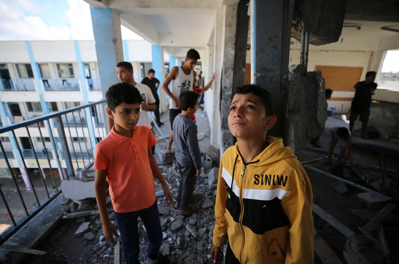 Palestinians inspect the damage at a school operated by the United Nations Relief and Works Agency for Palestine Refugees (UNRWA) after Israeli airstrikes targeted Al-Maghazi in the central Gaza Strip on Oct.18, 2023. (Getty Images Photo)