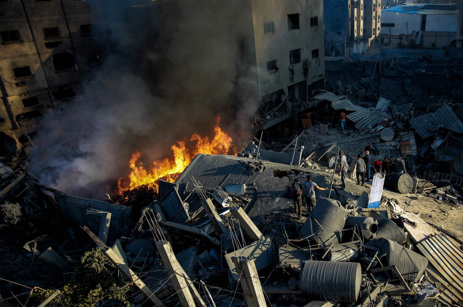 Palestinians stand on the rubble of a leveled building following an Israeli strike in Gaza City, Palestine, Oct. 26, 2023. (AFP Photo)