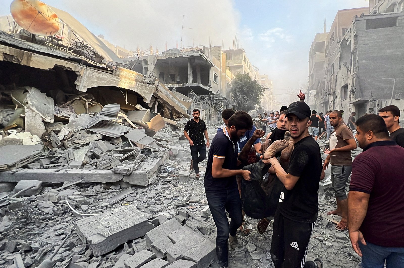 Palestinians carry a casualty at the site of Israeli strikes, in Gaza City, Palestine, Oct. 28, 2023. (Reuters Photo)
