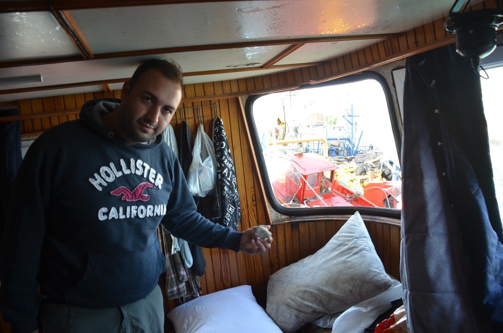 Ali Sarıhan shows smashed windows and a rock thrown at his boat by the Greek coast guard in the captain’s cabin, in western Aydın province, Türkiye, Oct. 30, 2023. (IHA Photo)