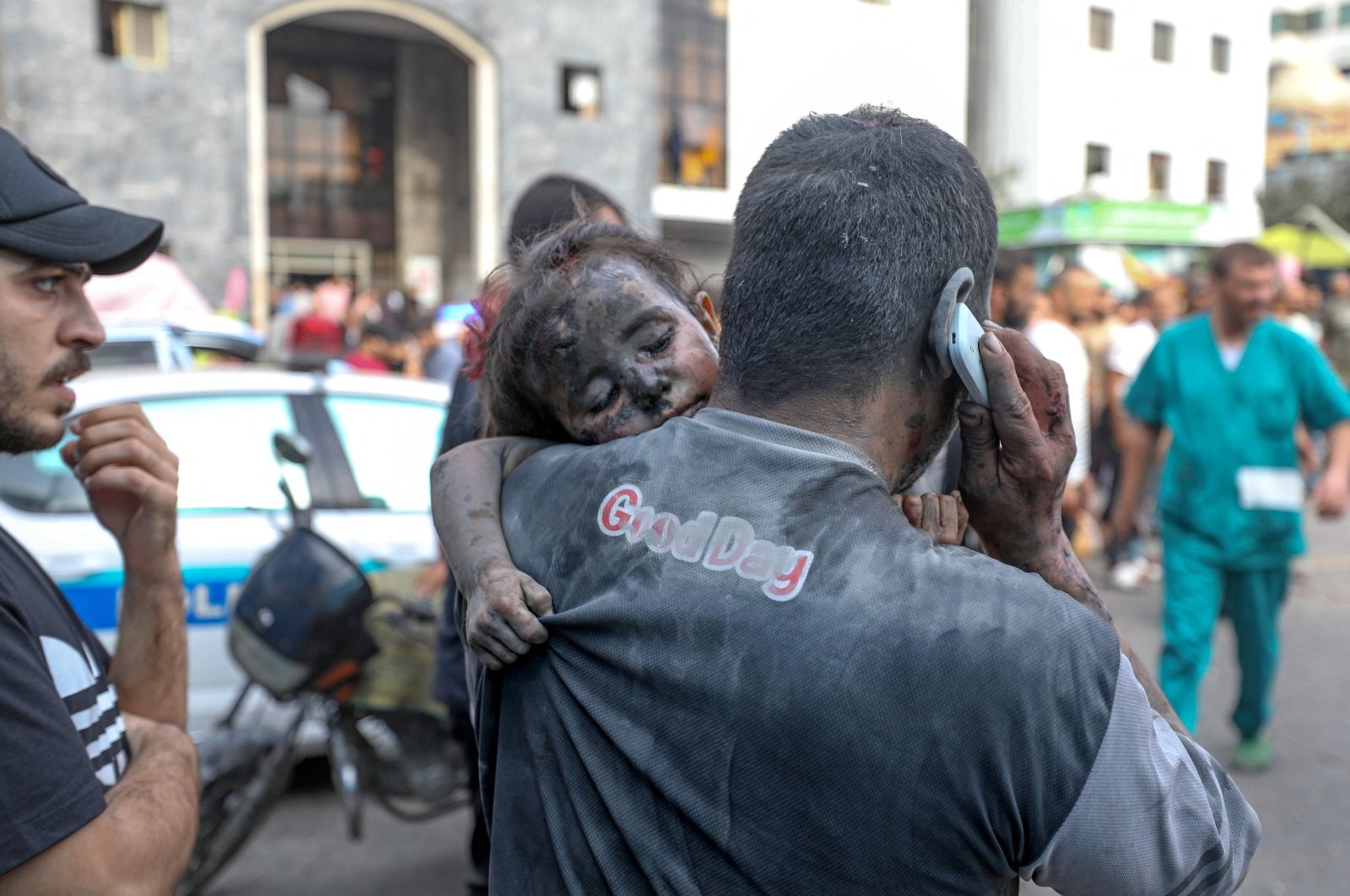 A Palestinian man covered in dust carries a baby girl into the Al-Shifa hopsital in Gaza City following Israeli strikes, Palestine, Oct. 29, 2023. (AFP Photo)