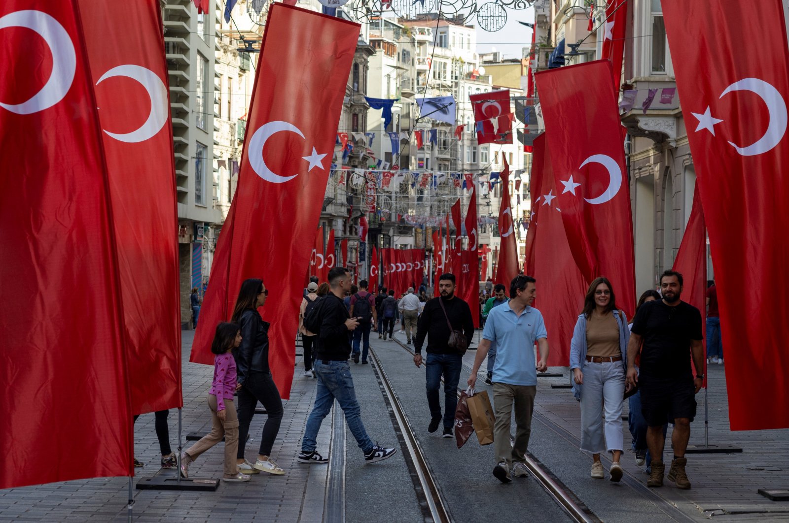 People walk along Istiklal Street, decorated with Turkish national flags, Istanbul, Türkiye, Oct. 27, 2023. (Reuters Photo)