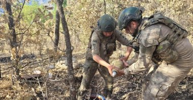 This photo taken in an undisclosed location shows soldiers examining munitions seized from PKK terrorists in Northern Iraq, July 29, 2023. (AA Photo)