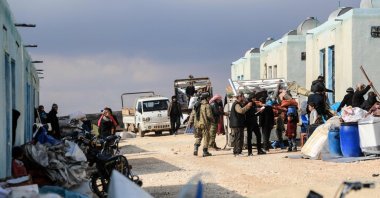 Syrians unload their belongings from trucks upon arrival at a new housing complex built with the support of Türkiye's emergencies agency AFAD, in the opposition-held area of Bizaah, east of the city of al-Bab in the northern Aleppo governorate, Syria, on Feb. 9, 2022 (AFP Photo)