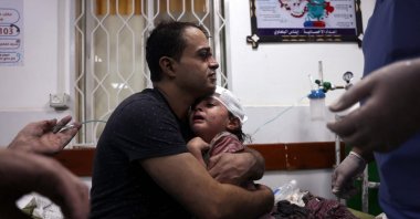 A Palestinian man cradles an injured child at the Najjar Hospital following an Israeli airstrike on a home in Rafah, in the southern Gaza Strip, Palestine, Oct. 30, 2023. (AFP Photo)