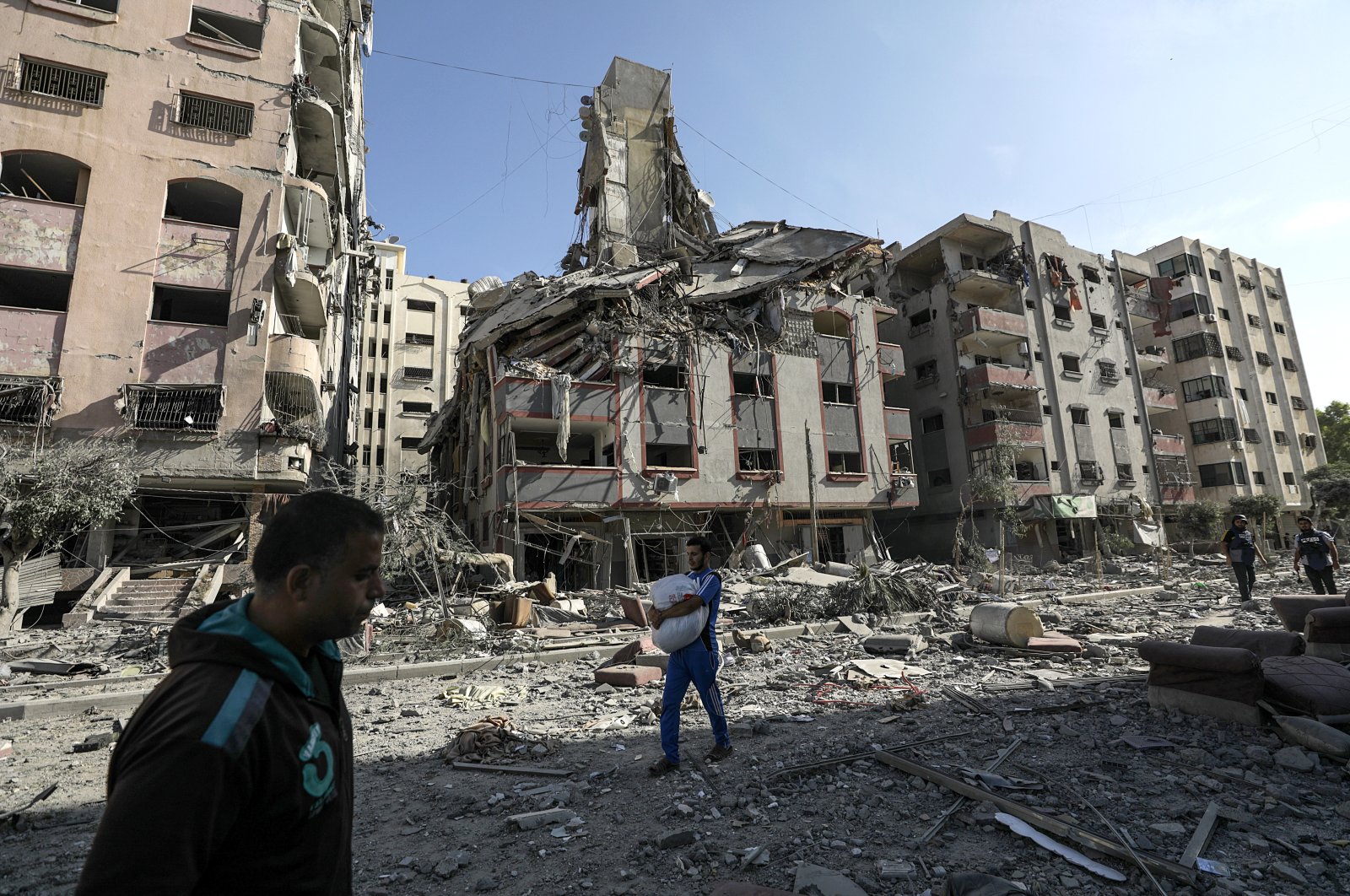 Palestinians walk among the rubble of destroyed residential buildings following Israeli airstrikes on the Tel al-Hawa neighborhood, in Gaza City, Palestine, Oct. 30, 2023. (EPA Photo)