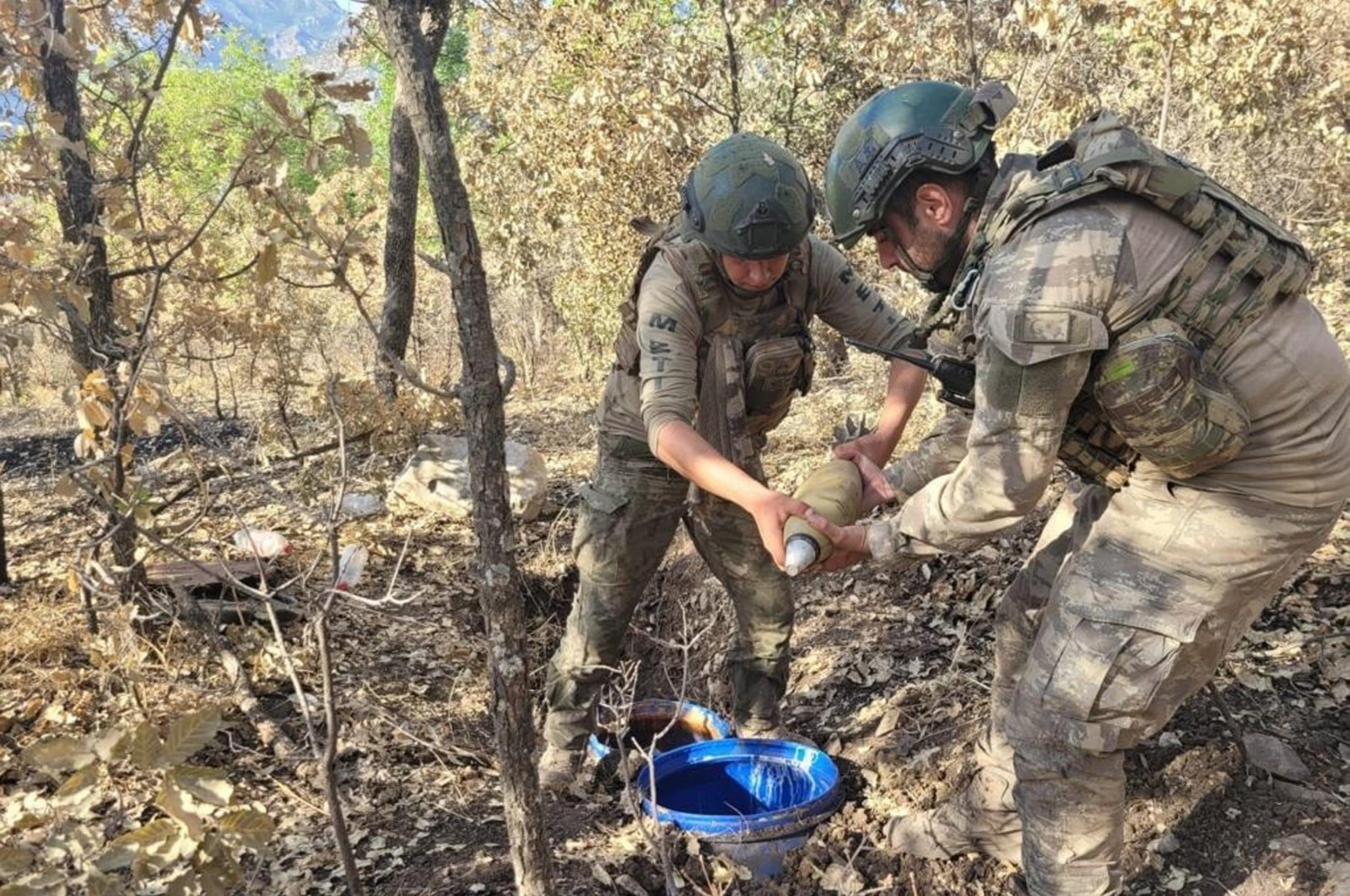 This photo taken in an undisclosed location shows soldiers examining munitions seized from PKK terrorists in Northern Iraq, July 29, 2023. (AA Photo)