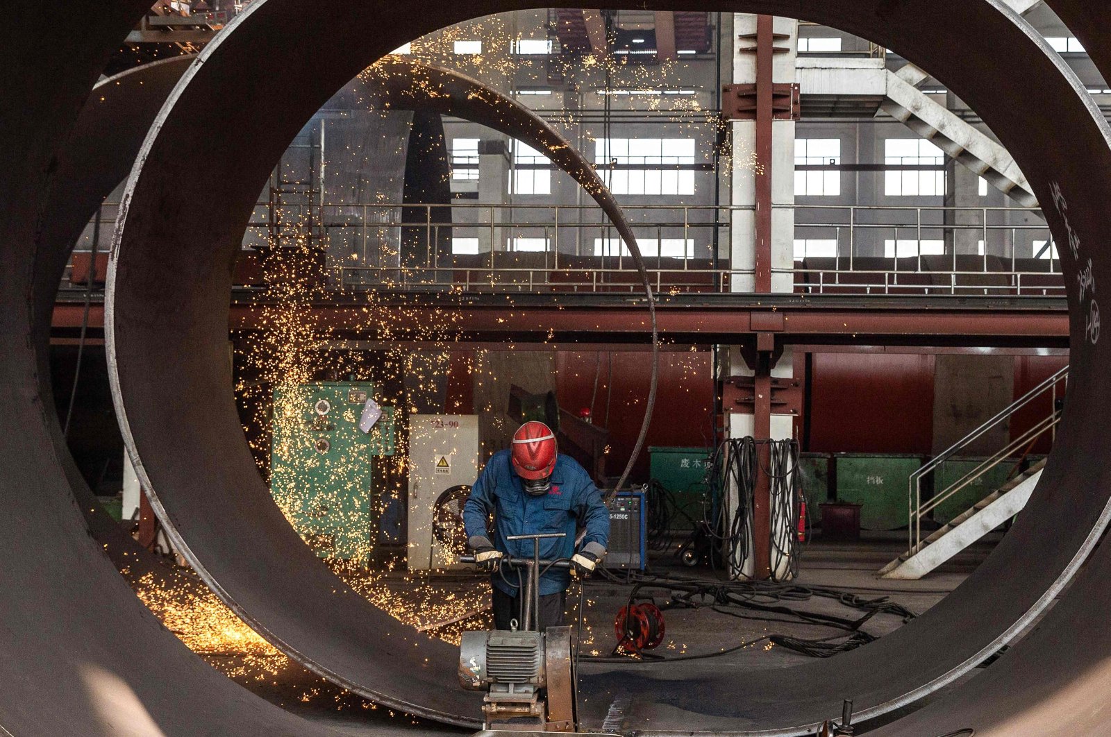 An employee works on a large construction equipment at a factory in Haian city, in China&#039;s eastern Jiangsu province, China, Oct. 16, 2023. (AFP Photo)